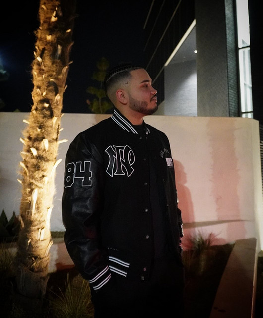Slllky in a black varsity jacket at night